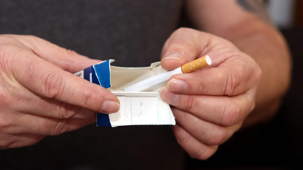 Ein Mann greift zur letzten Zigarette: Raucher müssen für BU- und Risikolebensversicherungen häufig deutlich mehr zahlen.