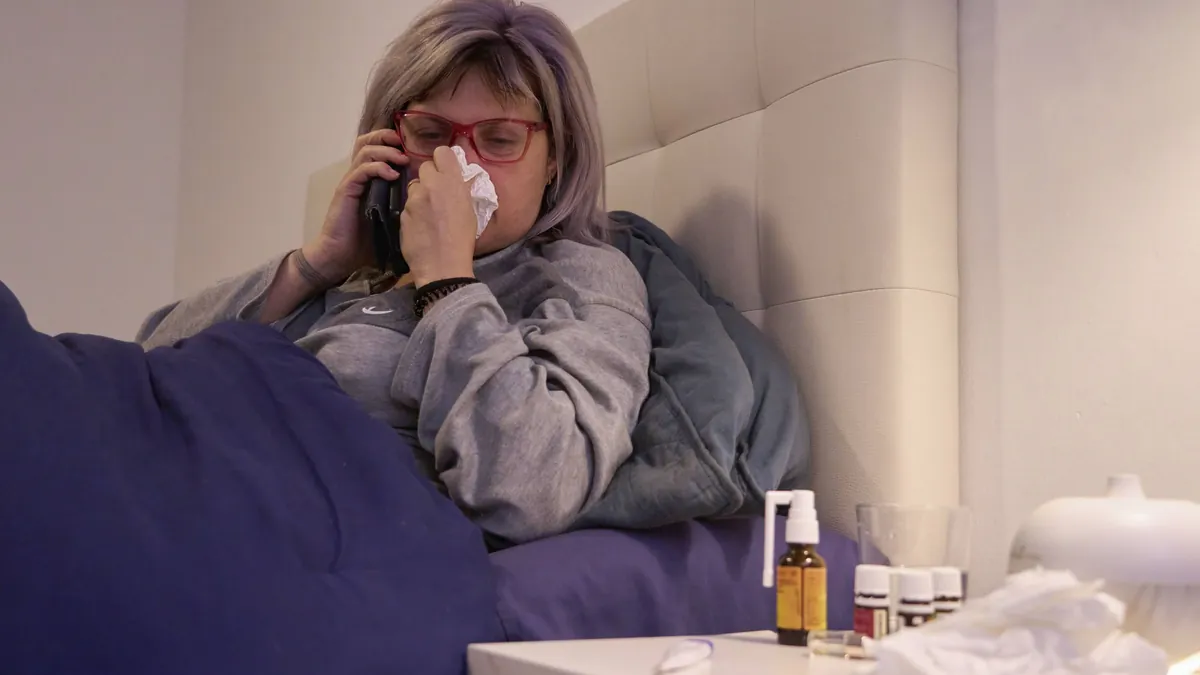 Eine kranke Frau am Telefon: Krankenkassen sollen mehr Rechte bekommen, Bezieher von Krankengeld zu kontaktieren.