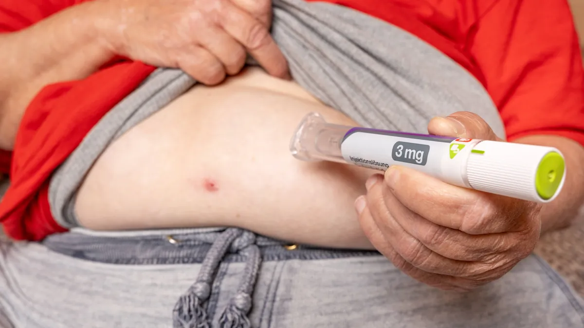 Mann setzt Abnehmspritze am Bauch an: Versicherungen zahlen für Abnehmspritzen nur unter strengen Bedingungen.