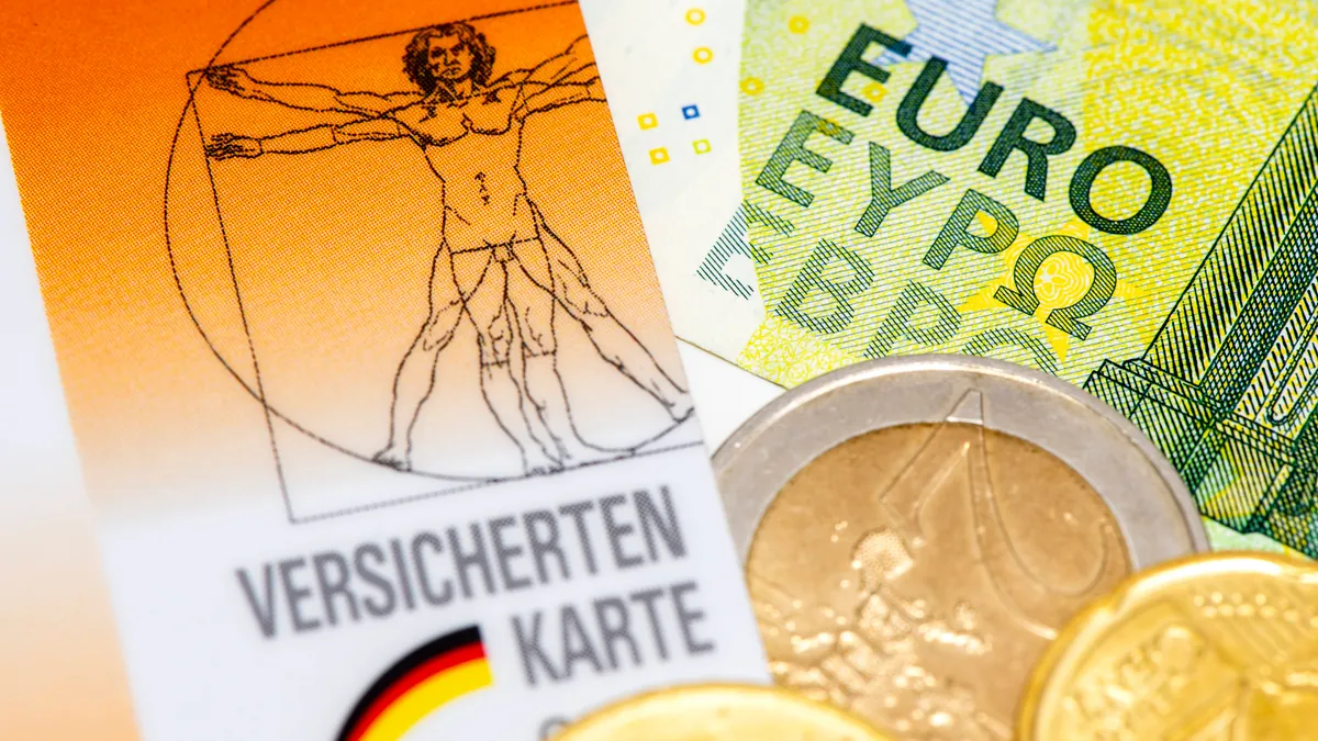 Gesundheitskarte und Geld: Eine große Krankenkasse passt ihren Zusatzbeitrag an.