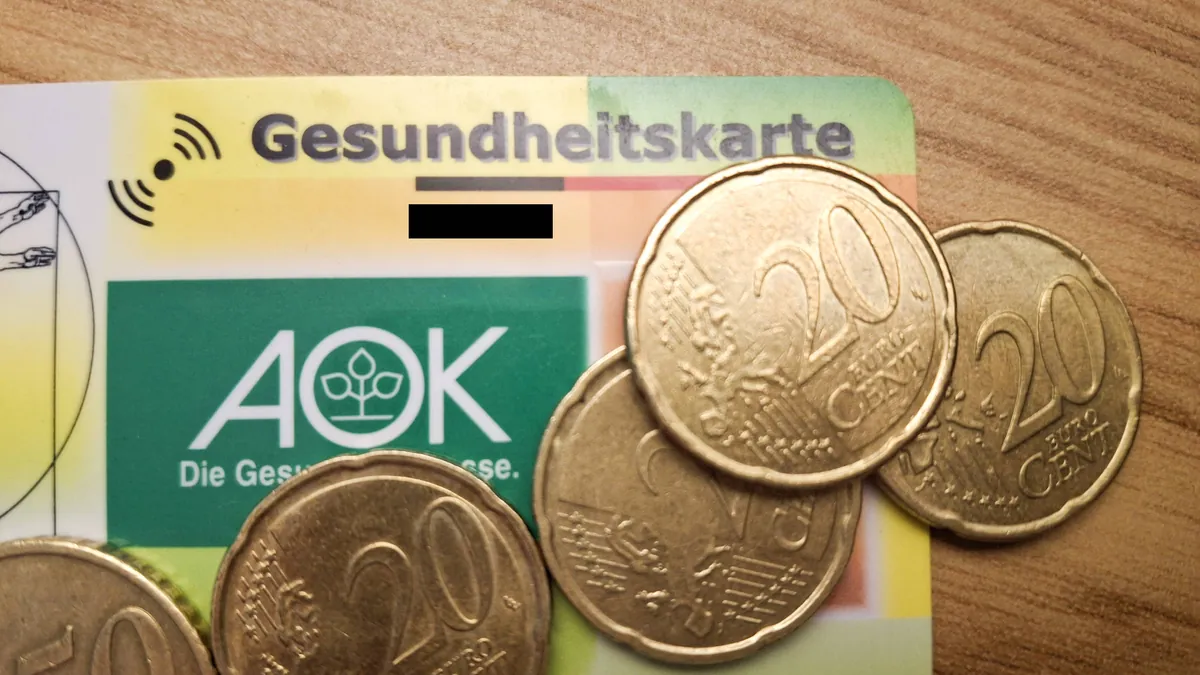 Krankenkassenkarte mit Geldmünzen: Auch bei Beitragsrückständen darf die Gesundheitskarte nicht gesperrt werden.